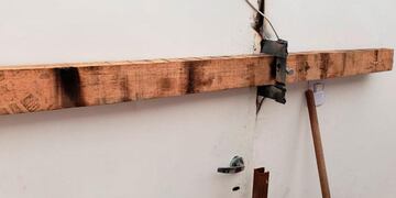 Tras el destrozo de la puerta del local, el dueño recurre a una tranca de madera para que no le sigan robando.