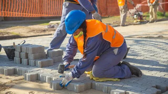 Dos mujeres de Pérez trabajan colocando adoquines en las calles en barrio 78 Viviendas (La Capital)