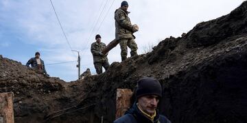 Los ciudadanos locales entierran cuerpos de soldados rusos en fosas comunes luego de los combates.