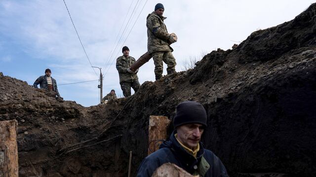 Los ciudadanos locales entierran cuerpos de soldados rusos en fosas comunes luego de los combates.
