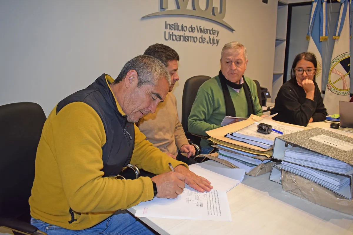 Sergio Aramayo, presidente del Colegio de Ingenieros de Jujuy, firma la documentación del trámite cumplido en el IVUJ. Al centro, el titular del organismo, José Luis Paiquez.