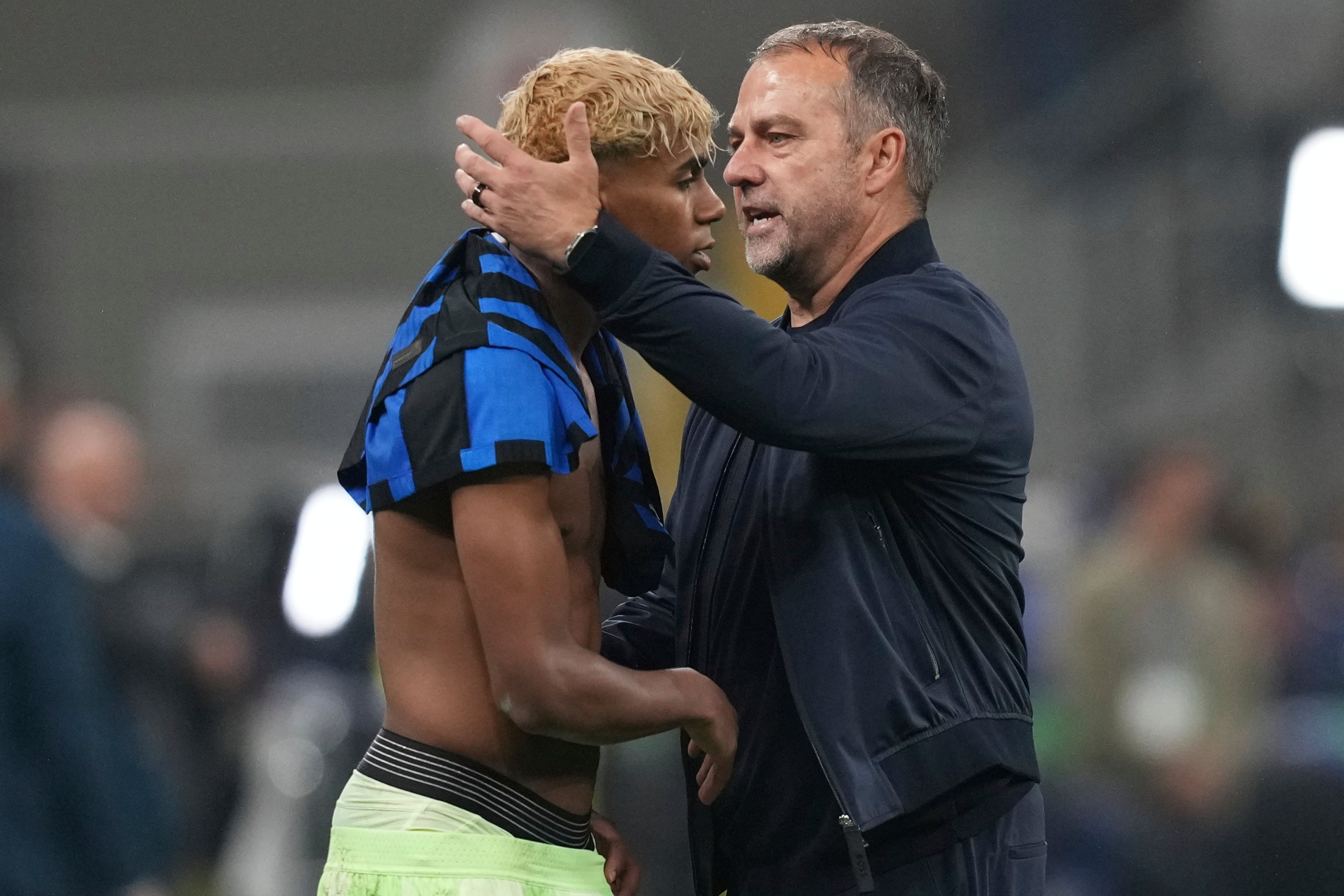 El técnico del Barcelona Hansi Flick consuela a Lamine Yamal tras la eliminación en las semifinales de la Liga de Campeones, el martes 6 de mayo de 2025, en Milán. (AP Foto/Antonio Calanni)