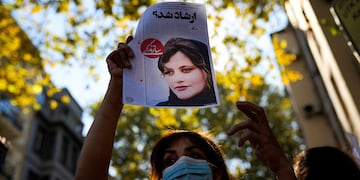 Una mujer sostiene una copia de un artículo de periódico con la foto del iraní Mahsa Amini que dice en persa: "¿Era Ershad?" durante una protesta contra la muerte de Amini, frente al consulado general de Irán en Estambul, Turquía. (AP)