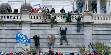 Simpatizantes de Donald Trump escalan un muro del Capitolio. (Foto: AP)