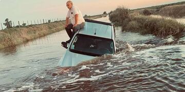 Productor se sentó en el techo de su camioneta ante la inundación de un camino rural