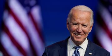El presidente electo Joe Biden sonríe mientras habla en el teatro Queen en Wilmington.