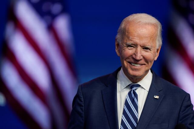 El presidente electo Joe Biden sonríe mientras habla en el teatro Queen en Wilmington.