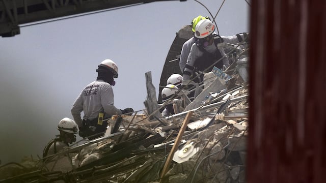 Bomberos y rescatistas trabajan entre los escombros del edificio que colapsó este jueves por la madrugada en Surfside, Miami.