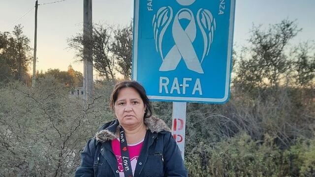 La mamá de Rafael Arnaldo Morales Miranda junto al cartel con un ángel azul que lo recuerda.