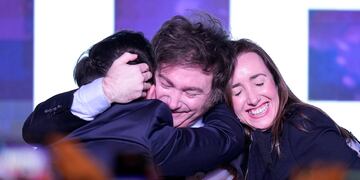 Javier Milei abraza a sus compañeros Ramiro Marra y Victoria Villarruel. (AP)