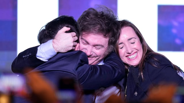Javier Milei abraza a sus compañeros Ramiro Marra y Victoria Villarruel. (AP)