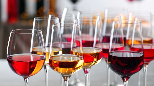 Glasses with different wines on blurred background, closeup