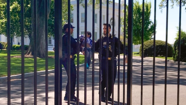 Agentes del Servicio Secreto con un niñito que se metió por la cerca de la Casa Blanca en Washington. Foto: AP / Nancy Benac.