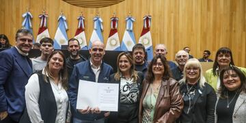 Gustavo Beccaría, promotor de Rally Cordobés, exhibe la distinción de la Legislatura, junto a Mungi, legisladores y pilotos; entre ellos, Gabriel Pozzo.