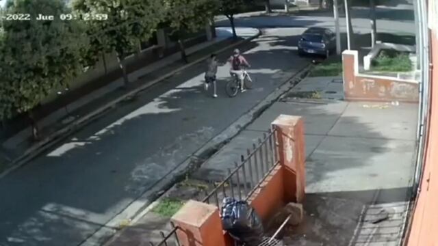 El momento en el que el ladrón tira al piso al hombre que viajaba a su trabajo en bicicleta.