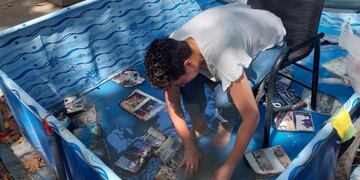 Una de las mujeres "rescatando" las fotografías de Carlitos de las llamas.