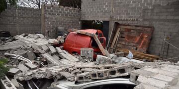 Cuatro autos aplastados al derrumbarse una pared por el fuerte viento en barrio Carcano de la ciudad de Córdoba. El propietario contó que se escuchó una explosión fuerte cuando todo se vino abajo. (Pedro Castillo/ La Voz)