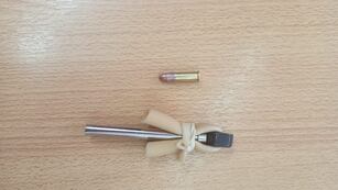 La tumbera y la bala encontrada en la Escuela "Mario R. Vecchioli"