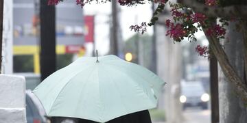 Los cordobeses se cubren de la lluvia.