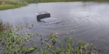 Un automóvil quedó dentro de una laguna artificial.