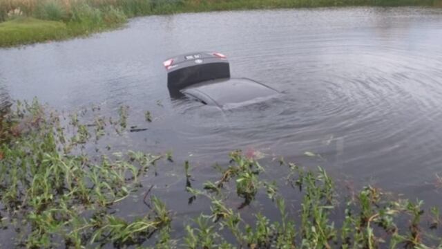 Un automóvil quedó dentro de una laguna artificial.