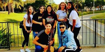 El cantante (quien sostiene la guitarra) junto a un grupo de jovencitas que fueron oyentes de sus canciones.