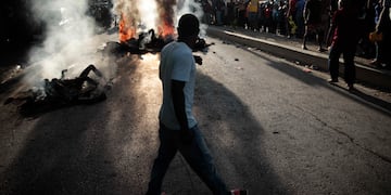 Un grupo de personas observa los cadáveres de presuntos pandilleros que fueron quemados vivos por una turba en la sección Canape Vert de Puerto Príncipe, Haití, el lunes 24 de abril de 2023. Foto: AP / Odelyn Joseph,