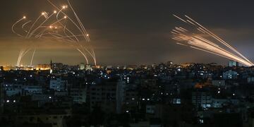 Cohetes en el cielo nocturno disparados hacia Israel desde Beit Lahia en el norte de la Franja de Gaza el 14 de mayo de 2021. - Israel atacó Gaza y desplegó tropas adicionales en la frontera mientras los palestinos disparaban bombardeos de cohetes, con el número de muertos en el enclave. en el cuarto día de conflicto subiendo a más de 100.