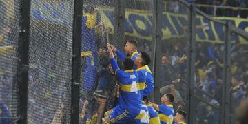 Darío Benedetto, bien arriba del alambrado, y todo Boca festejan la apertura del marcador en el clásico con River. (Clarín)