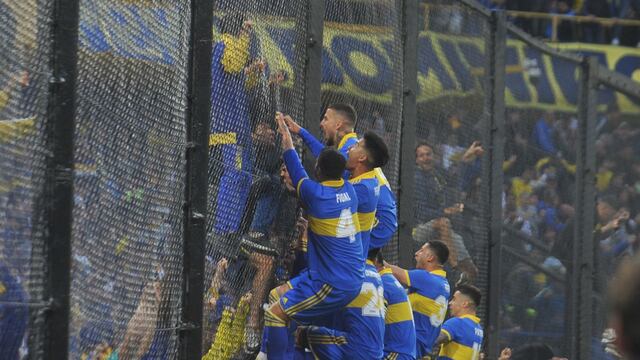Darío Benedetto, bien arriba del alambrado, y todo Boca festejan la apertura del marcador en el clásico con River. (Clarín)