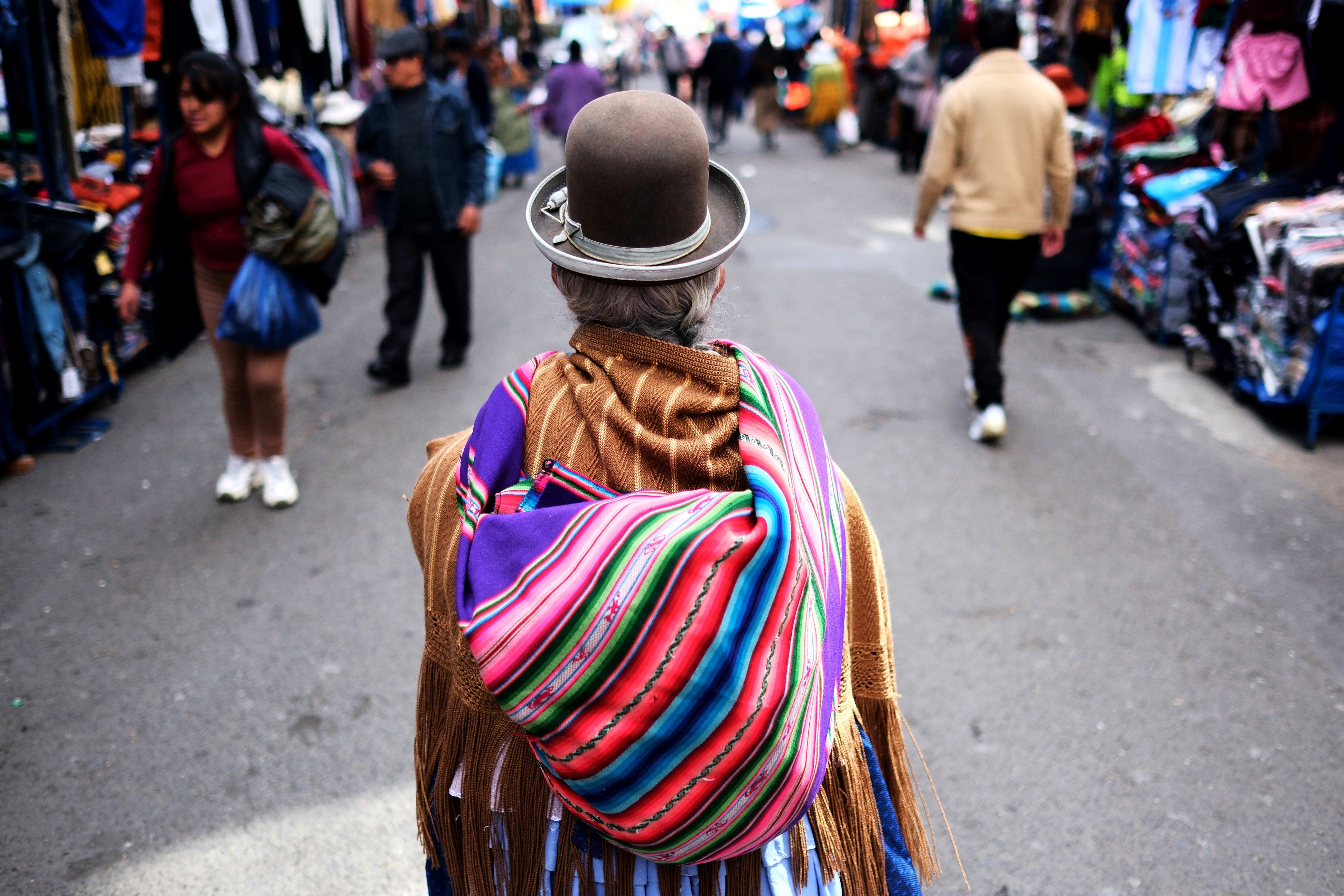 Una mujer aimara camina en un mercado popular, en La Paz (Bolivia). El presidente Paz prepara anuncios que permitirán "visualizar claramente el destino de la patria", dijo.