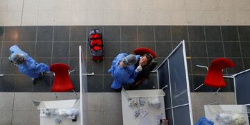 Un trabajador de la salud realiza un hisopado de coronavirus a una mujer en una terminal de autobuses en Buenos Aires. (Foto: REUTERS / Agustin Marcarian)