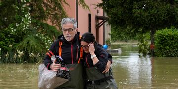 Una pareja camina en una carretera inundada de Lugo, Italia. (AP)