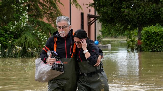 Una pareja camina en una carretera inundada de Lugo, Italia. (AP)