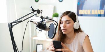 Nota de tapa 929 Rumbos Podcast
Cute Latin broadcaster and blogger reading comments from fans on social media during a live podcast