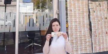 Fiona Cavazzon, de Sumar, empapeló la puerta del Banco Nación en Córdoba.