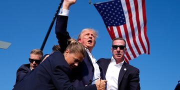 ARCHIVO - El entonces candidato republicano a la presidencia Donald Trump es protegido por agentes del Servicio Secreto en un atentado en su contra durante un acto de campaña el 13 de julio de 2024, en Butler, Pensilvania. Trump, ahora presidente electo, nombrará director del Servicio Secreto a Sean Curran, derecha. (AP Foto/Evan Vucci, archivo)