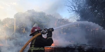 Bomberos trabajaron para combatir el fuego que azotaba las viviendas.