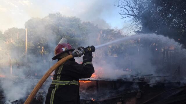 Bomberos trabajaron para combatir el fuego que azotaba las viviendas.