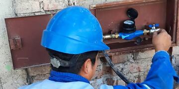 Un operario de Agua Potable de Jujuy verifica el funcionamiento de un medidor de consumo, de un usuario residencial.