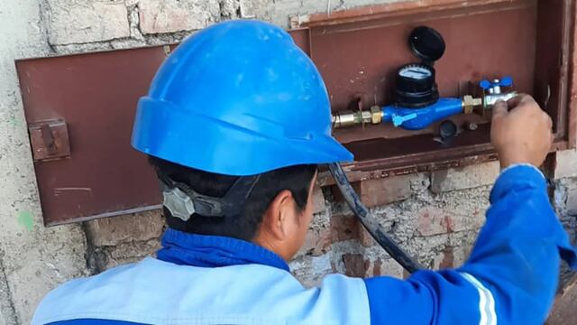 Un operario de Agua Potable de Jujuy verifica el funcionamiento de un medidor de consumo, de un usuario residencial.