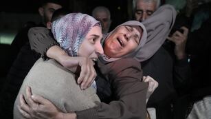 Shuruq Dwayat, a la izquierda, una prisionera palestina liberada por Israel, es abrazada por familiares a su llegada a casa en el vecindario de Sur Bahar, en Jerusalén Oriental, el domingo 26 de noviembre de 2023.