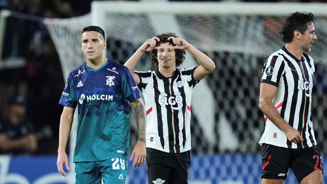 Iván Franco festeja el 1-0 de Libertad. Lo sufre Gastón Benavídez, de Talleres. (AP)