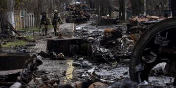 Soldados caminan entre tanques rusos destruidos en Bucha, en las afueras de Kiev. Allí denuncian que se cometieron crímenes de guerra. (AP)