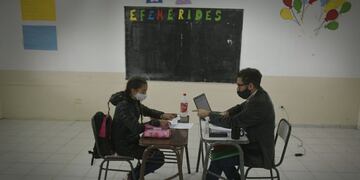 Sebastián Giménez da clases a Naikén, una de las niñas de séptimo grado que regresó a uno de los municentros del barrio La Favorita. / Orlando Pelichotti -Los Andes