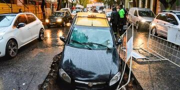 En medio de un temporal de lluvia un taxi terminó en un pozo de ASSA