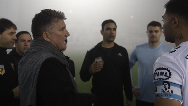 Luis Artime, presidente de Belgrano, dialogando con el árbitro y con los jugadores de Quilmes sobre la suspensión del partido por la niebla. (Federico López Claro / La Voz)