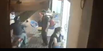 La inseguridad no da respiro a sufridos cordobeses como este cliente asaltado por un motochoro en la vereda de una heladería (imagen de video).
