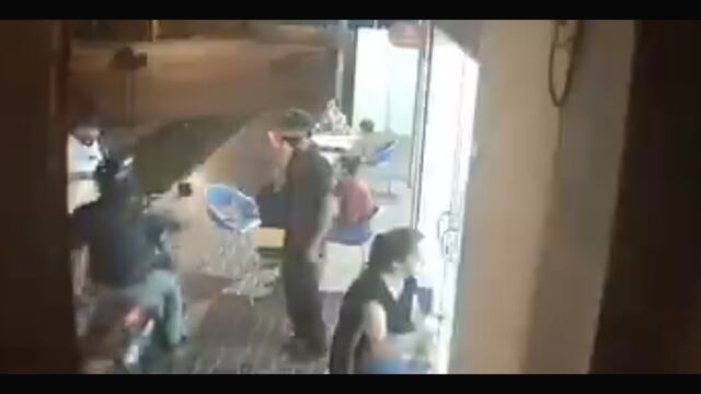 La inseguridad no da respiro a sufridos cordobeses como este cliente asaltado por un motochoro en la vereda de una heladería (imagen de video).