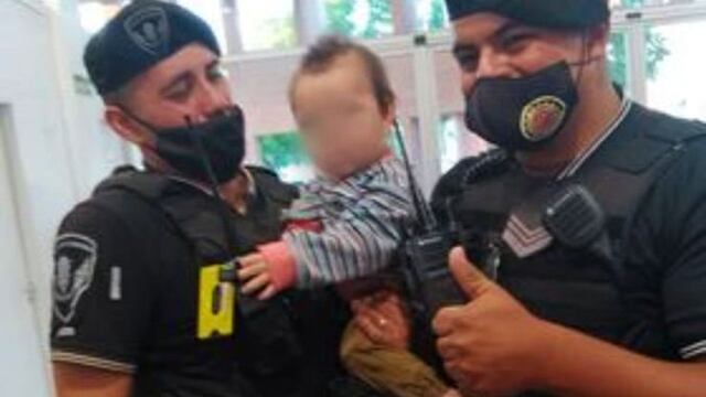 Jorge Moscardini y  Daniel Barros,  con el bebé al que salvaron, en Villa el Libertador.